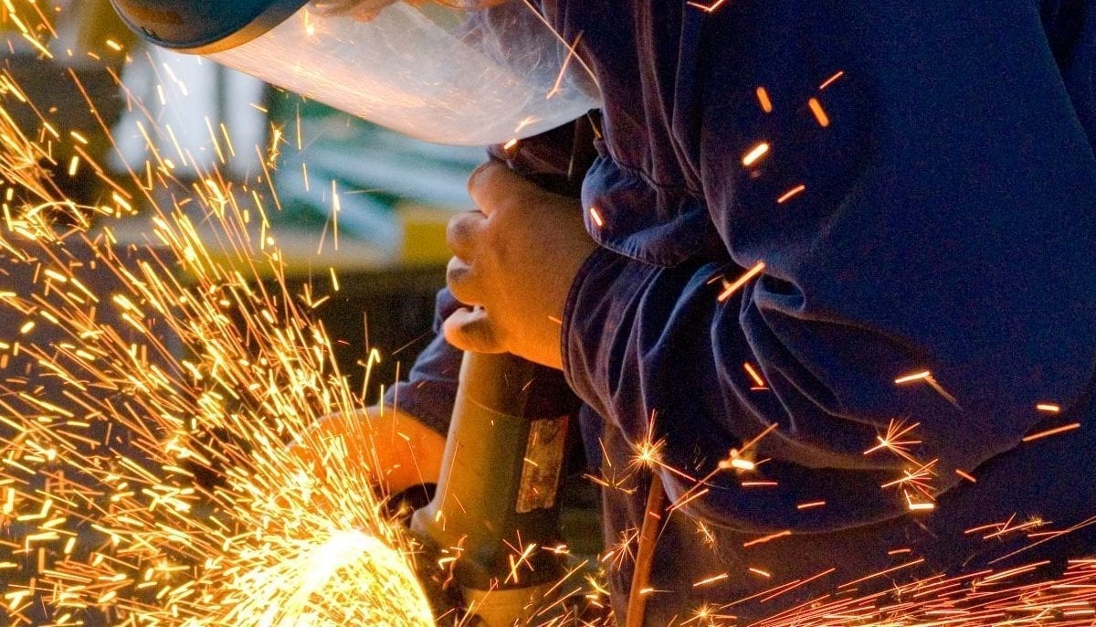 Men at work grinding steel