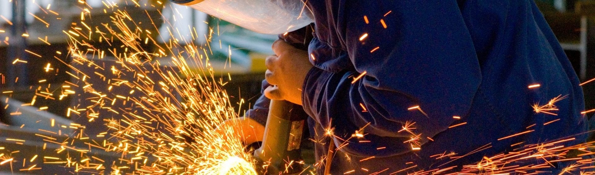 Men at work grinding steel